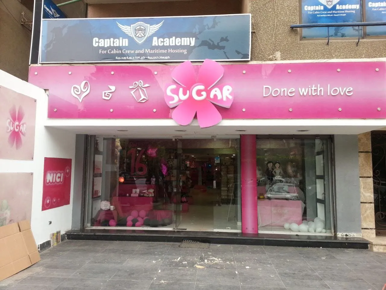 واجهة محل "Sugar" للهدايا والديكورات الوردية الاحتفالية مع لافتة "Done with love".