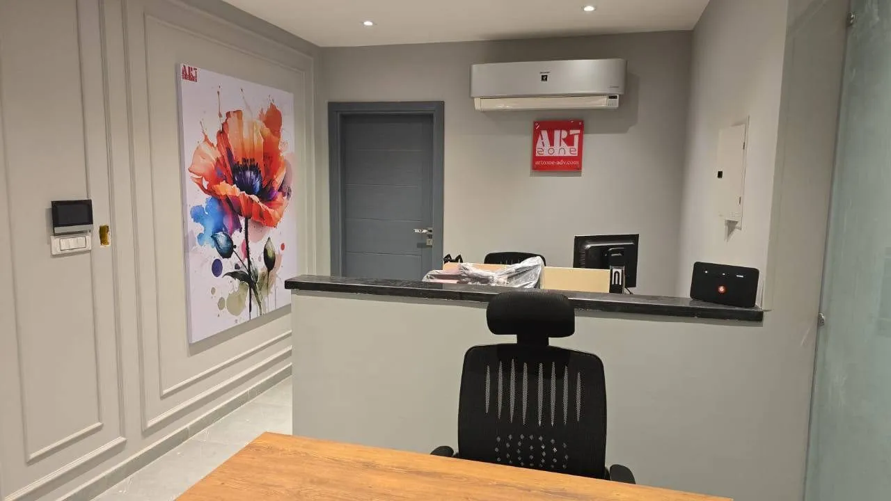 مكتب استقبال حديث لـ Art Zone للدعاية والإعلان مع لوحة فنية لزهرة الخشخاش.
