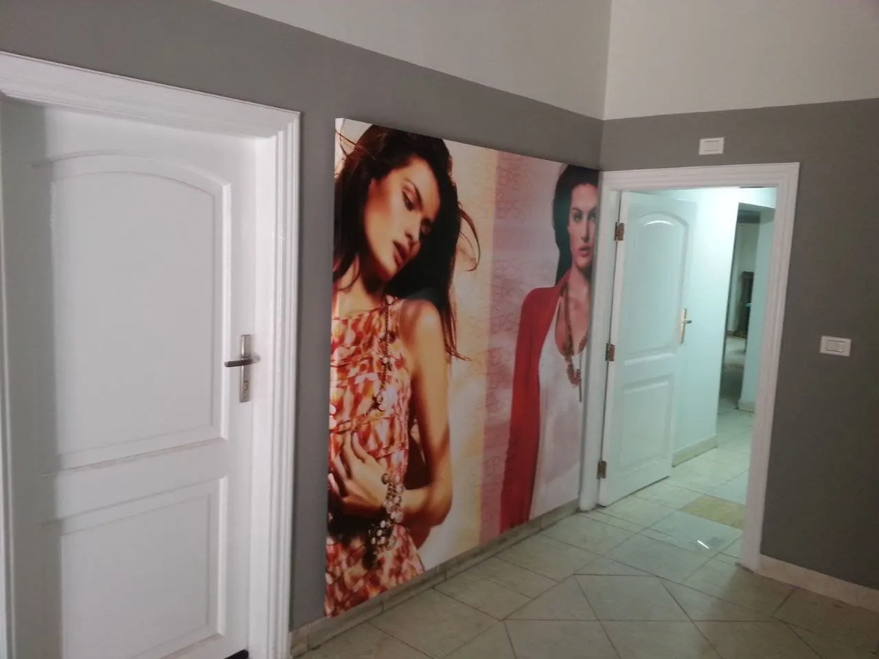 ملصق أزياء نسائي حديث في بهو داخلي رمادي مع أرضية مبلطة.