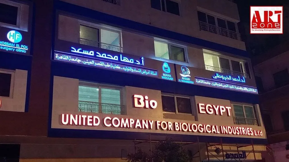 واجهة مبنى ليلي لعيادات وأعمال صناعية بلافتات مضيئة لـ "UNITED COMPANY FOR BIOLOGICAL INDUSTRIES".