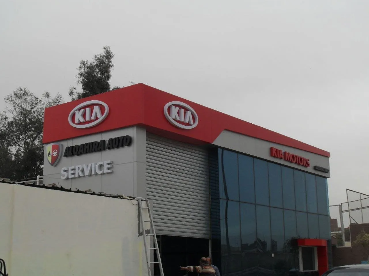 واجهة مركز خدمة كيا (KIA) "القاهرة أوتو" بتصميم عصري وألوان حمراء ورمادية.