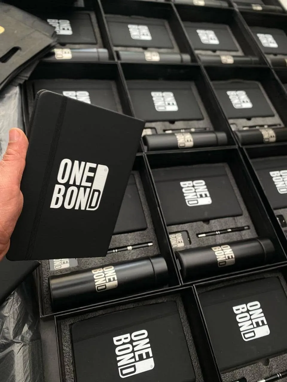 مجموعات هدايا شركات أنيقة "ONE BOND" سوداء مع دفاتر وأقلام جاهزة للتوزيع.