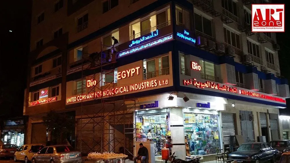 واجهة ليلية لمبنى شركة "UNITED COMPANY FOR BIOLOGICAL INDUSTRIES L.t.d" و"Bio" مضاءة بالنيون.
