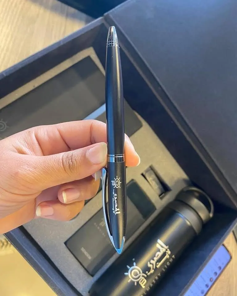 قلم فاخر أسود غير لامع وشعار فضي فوق مجموعة هدايا ترمس أنيقة.