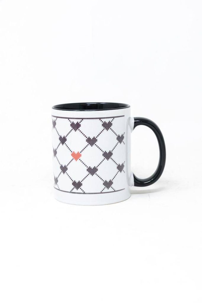 مج سيراميك أبيض بتصميم قلوب سوداء وشكل تطريز، مقبض أسود.